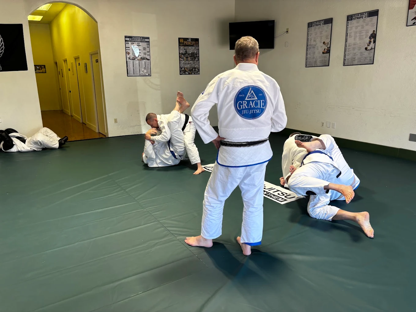 Instructor watching students drill on the mats