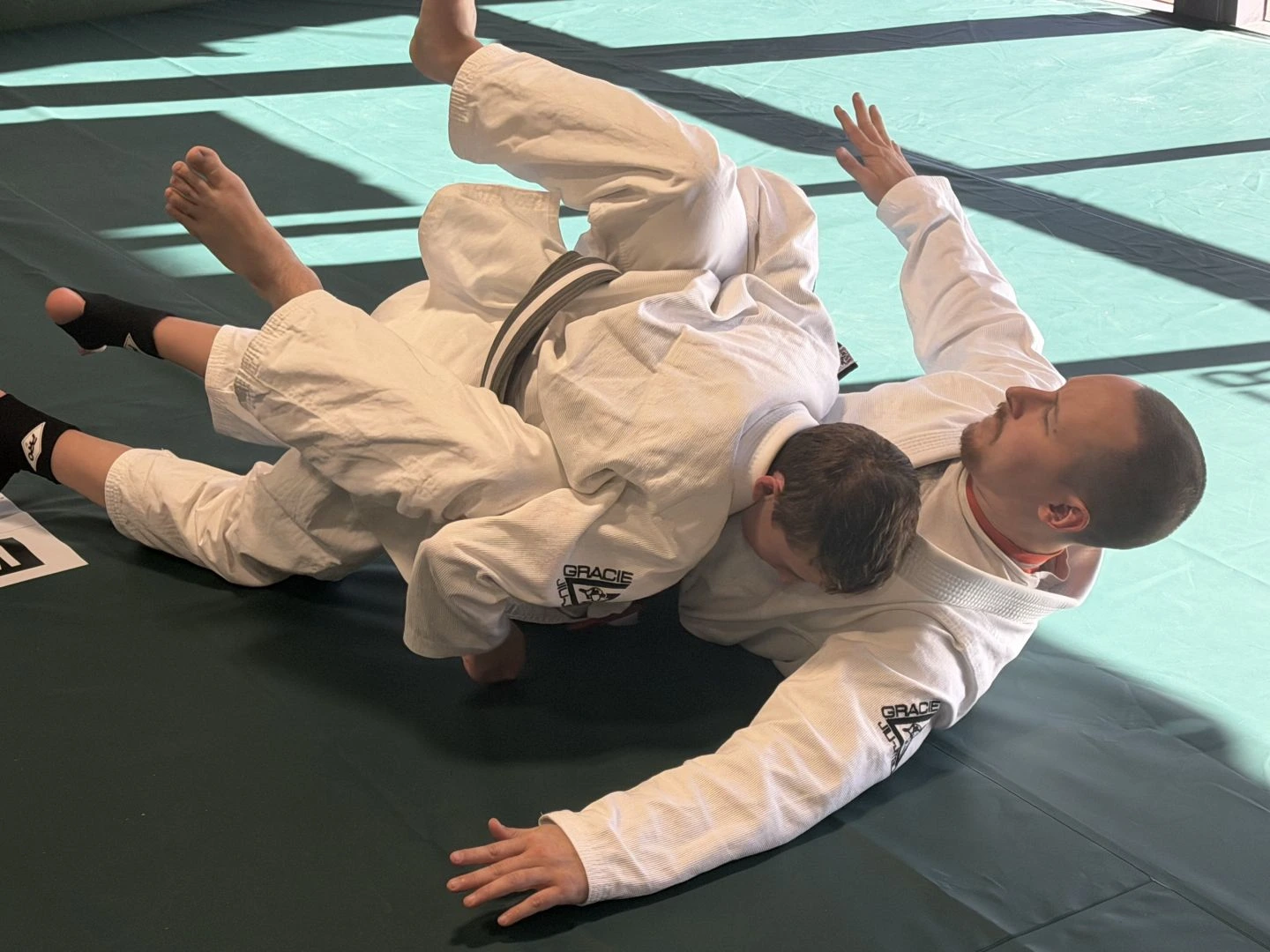 Students practicing Brazilian Jiu-Jitsu on the mats