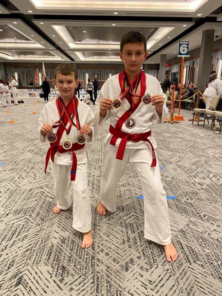 Students posing with medals at a martial arts tournament
