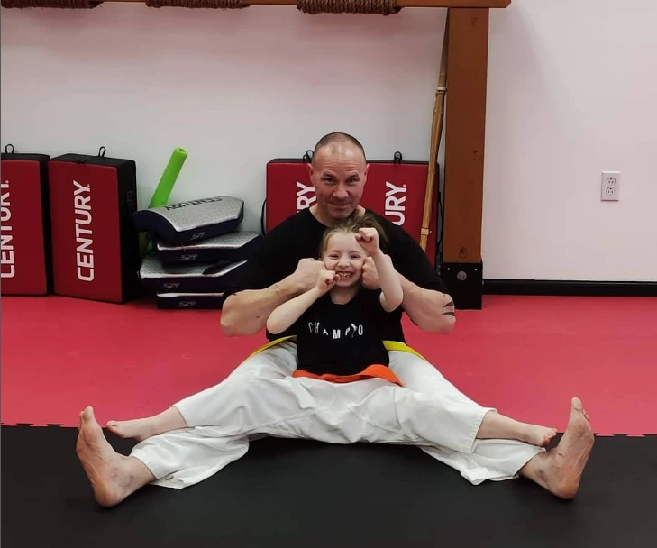 Instructor and child smiling on the mat at Champion Martial Arts