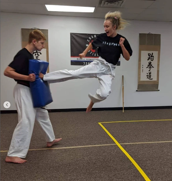 Student practicing a flying kick at Champion Martial Arts