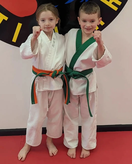 Two young Champion Martial Arts students posing with raised guard hands