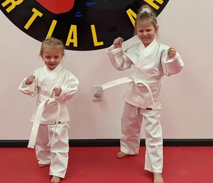 Two young Champion Martial Arts students posing in white uniforms