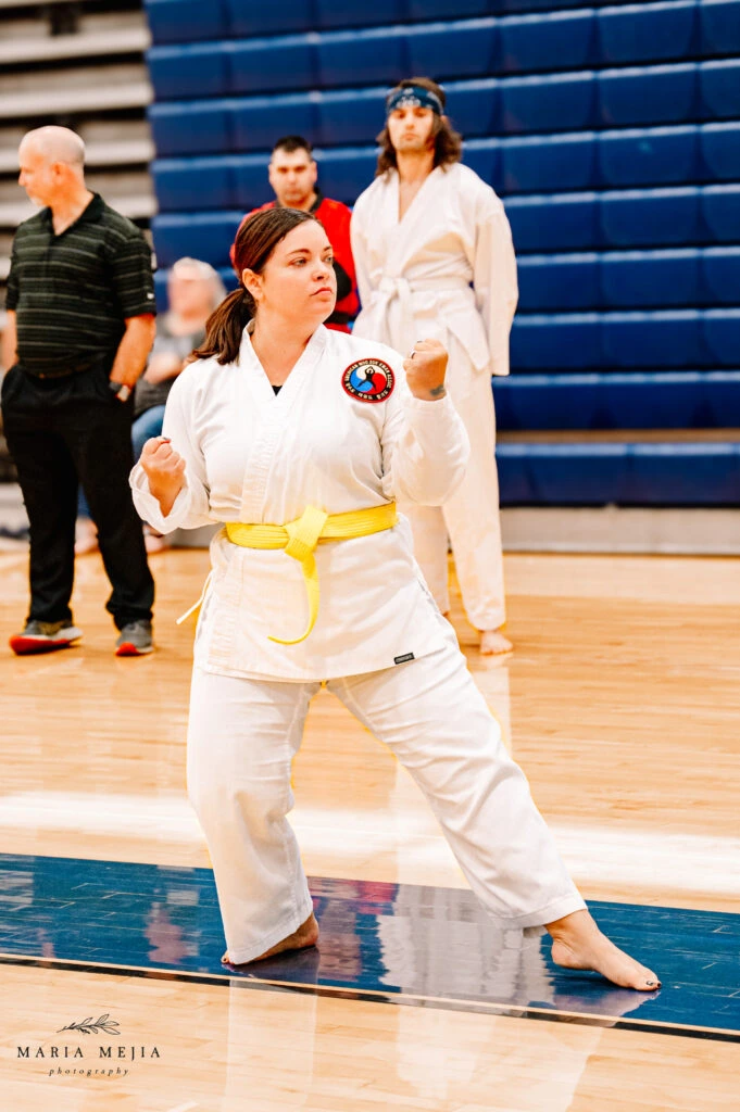 Adult student performing a martial arts form during a tournament
