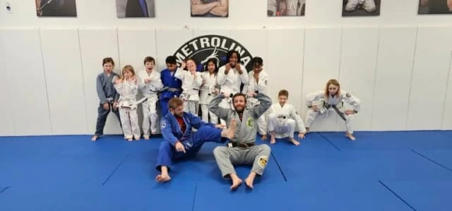Students and instructor posing together on the mat at Metrolina Martial Arts