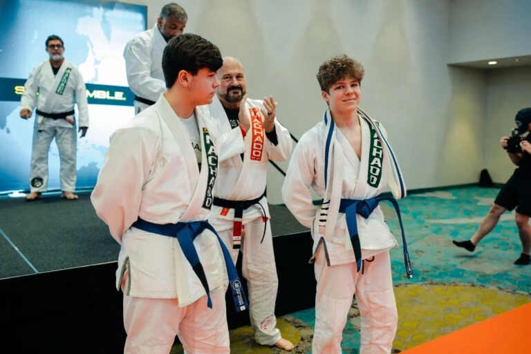 Students receiving Brazilian Jiu Jitsu belts at a tournament event