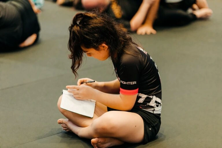 Student taking notes during martial arts training