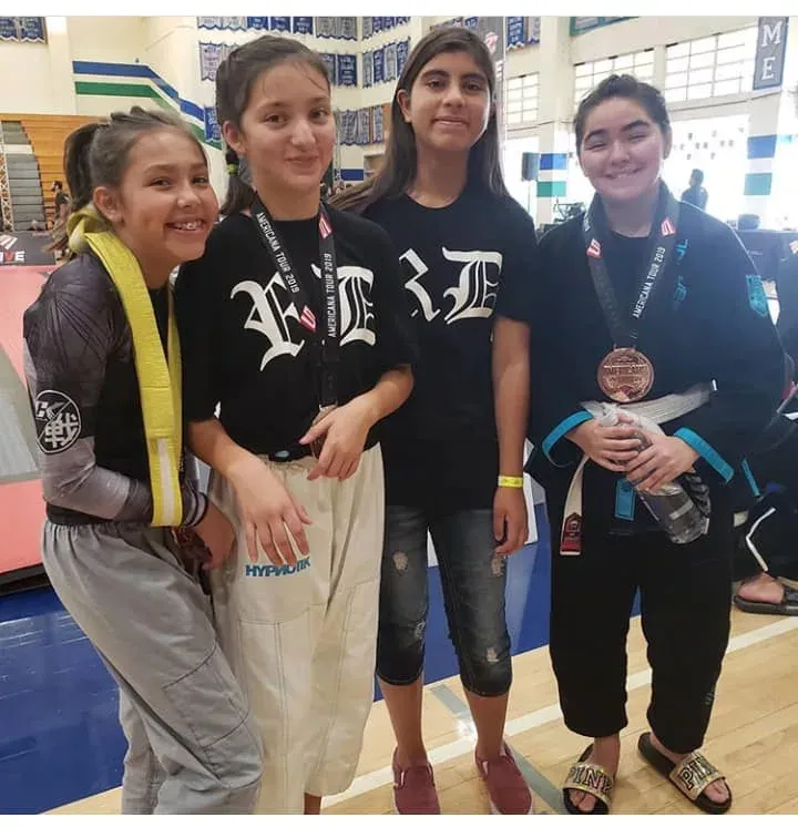 Youth students posing with medals at a tournament